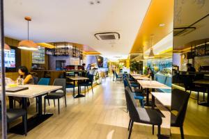 a restaurant with tables and chairs and people sitting at them at Samran Place Hotel in Bangkok