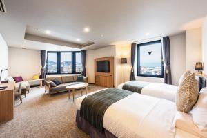 um quarto de hotel com duas camas e um sofá em Hotel Nord Otaru em Otaru