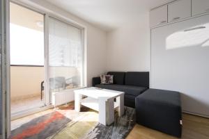 a living room with a couch and a table at Luxury Studio Apartment Miljacka Sarajevo in Sarajevo