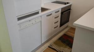 uma cozinha branca com um fogão e um lavatório em Luxury Studio Apartment Miljacka Sarajevo em Sarajevo