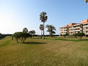 a park with palm trees and a building at Gava Beach 1st Line in Gavà