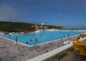 a large blue swimming pool with people in it at Sintra Sol - Apartamentos Turisticos in Sintra