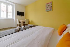 1 dormitorio con 1 cama y 1 mesa con sillas en Piranika, en Piran
