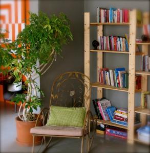 a chair in front of a book shelf with books at Yucca Alaçatı in Alacati