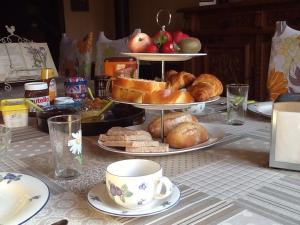 a table with three plates of pastries and bread at Chambres d'hôtes Le Forgeron in Châteaumur