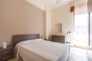 a bedroom with a bed and a dresser and a window at Balconies d'Orlando in Capo dʼOrlando