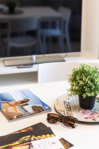 a table with a plate and a potted plant and glasses at Balconies d'Orlando in Capo dʼOrlando