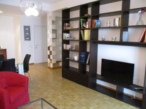 un soggiorno con grande TV e librerie di Casa Roby a Verona