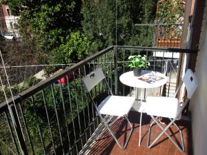 un balcone con 2 sedie, un tavolo e una pianta di Casa Roby a Verona