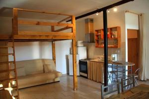 a living room with a loft bed and a kitchen at Ferme Equestre Les Coccinelles in Lurs