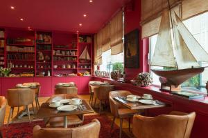 a restaurant with red walls and tables and a sailboat on the wall at Hôtel Spa Vent d'Ouest in Le Havre