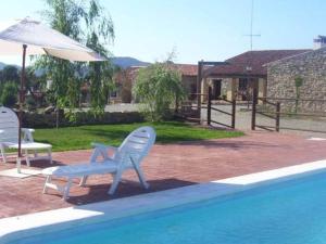 two chairs and an umbrella next to a swimming pool at Finca Los Caleros in Juan Gallegos +65 photos
