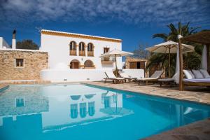 a villa with a swimming pool in front of a house at Casa Can Pep Cudula in Sant Llorenç de Balafia