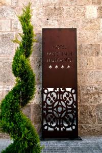 un panneau sur un mur de briques avec un arbre de Noël dans l'établissement Hotel Spa Martín el Humano, à Segorbe