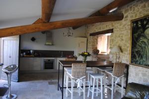 een keuken met een tafel en stoelen in een kamer bij Le Côté d'Elle in Niozelles