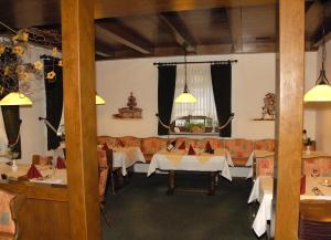a restaurant with tables and couches in a room at Hotel Stadtschänke in Bad König