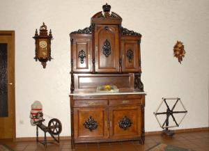 a large wooden cabinet against a wall with a clock at Hotel Stadtschänke in Bad König