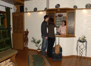 a man and a woman standing at a bar at Hotel Stadtschänke in Bad König