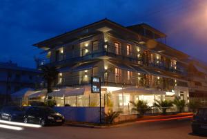 a building with cars parked in front of it at night at THE SILK Hotel in Paralia Katerinis