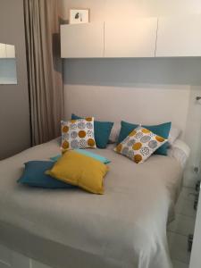 Una cama con cuatro almohadas encima. en Entre mer et mer en La Seyne-sur-Mer