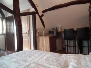 1 dormitorio con 1 cama y 2 sillas en L'Escapade de Marijac, en Lyons-la-Forêt