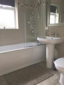 a bathroom with a sink and a tub and a toilet at Fir Tree Cottage in Chester