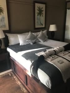 sypialnia z dużym łóżkiem z białymi poduszkami w obiekcie De Charmoy Estate w mieście Verulam