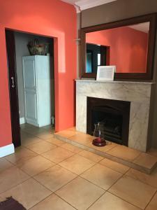 a living room with a fireplace and a mirror at De Charmoy Estate in Verulam