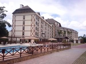 a large building with a pool in front of it at Flat Particular Pedra Azul in Pedra Azul