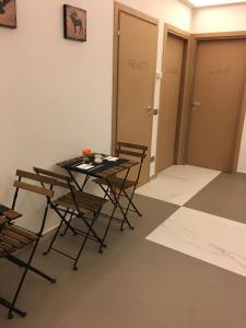 ミネルビオにあるB&B La Casa di Klidaのテーブルと椅子、2つのドアが備わる客室です。