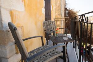 Duas cadeiras e uma mesa numa varanda em Casa Di Porto em Chania Town