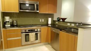 a kitchen with a stainless steel oven and a microwave at Brickell Deluxe Apartment with Free Parking in Miami