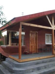 a wooden house with a porch and a deck at Cabañas El Sauce in Ensenada
