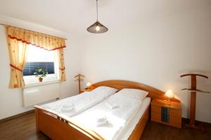 a bedroom with a bed with white sheets and a window at Haus Volksbank by Rujana in Binz
