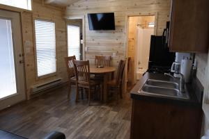 a kitchen with a table and chairs in a cabin at Pio Pico Camping Resort Cottage 1 in Jamul
