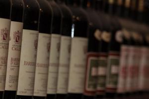una fila de botellas de vino en un estante en Agriturismo Il Ciabot, en Barolo