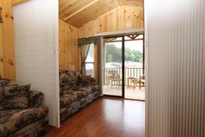 Una sala de estar con un sofá y una puerta corrediza de vidrio. en Blackhawk RV Campground Cabin 1, en Milton 8 fotos más