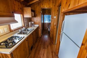 a kitchen with a sink and a refrigerator at Pio Pico Camping Resort One-Bedroom Cabin 13 in Jamul