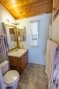a bathroom with a toilet and a sink and a mirror at Pio Pico Camping Resort One-Bedroom Cabin 13 in Jamul