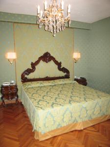 a bedroom with a bed with a chandelier at Cà Bollani in Venice