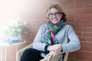 a woman sitting in a chair wearing a scarf at A due Passi in Forte dei Marmi