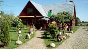 dom z kupą roślin przed nim w obiekcie Olsik w Białowieży