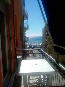 un balcone con tavolo bianco su un edificio di Apartment Serena ad Alassio