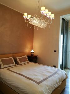 ein Schlafzimmer mit einem großen Bett mit einem Kronleuchter in der Unterkunft Casa Il Faro Deluxe in Porto Cesareo