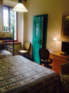 una camera con letto e scrivania e una camera da letto di Hotel Villa Patrizia a Cutigliano
