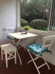 a desk and two chairs and a table and a window at Entre mer et mer in La Seyne-sur-Mer