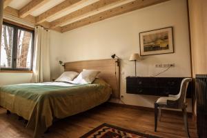 a bedroom with a bed and a chair and a window at Boisrouge in Flagey-Échézeaux