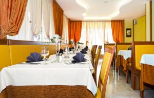 uma sala de jantar com uma mesa com uma toalha de mesa branca em Hotel Al Prater em Lignano Sabbiadoro