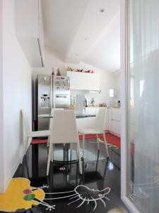 a kitchen with a table and chairs and a refrigerator at Miro' Holiday Attic in Bologna