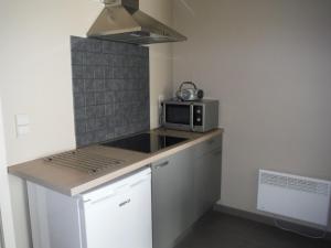 een kleine keuken met een magnetron op een aanrecht bij Residentie Royal Park in Oostende